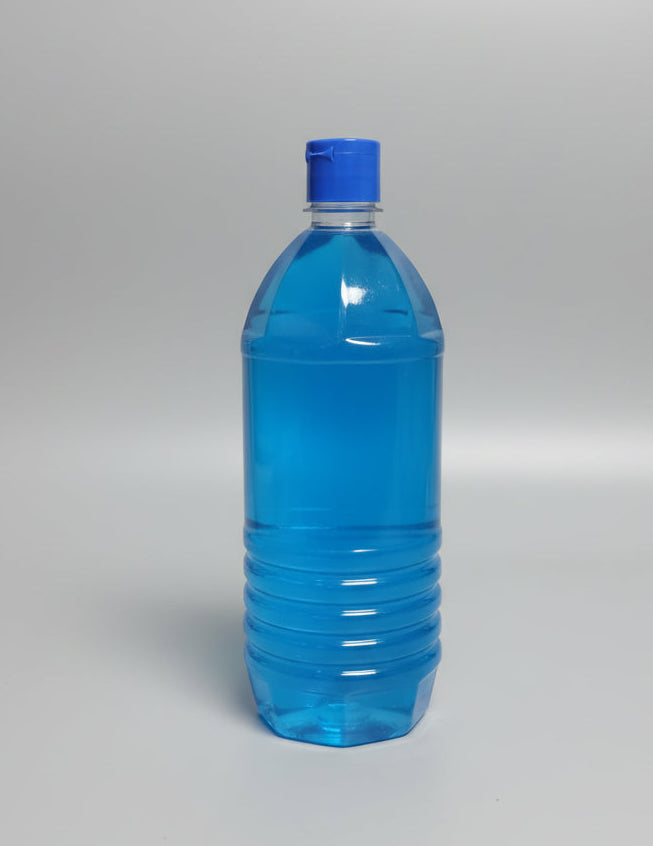 A back view studio shot of a clear plastic bottle with ridges near the bottom, filled with a vibrant fabric liquid. The bottle has a matching bright blue flip-top cap and is standing on a plain light grey background.